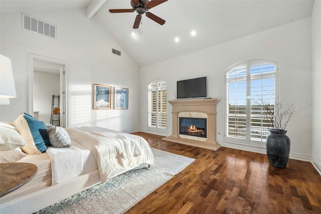 bedroom with a glass covered fireplace, dark wood-style flooring, visible vents, and beamed ceiling