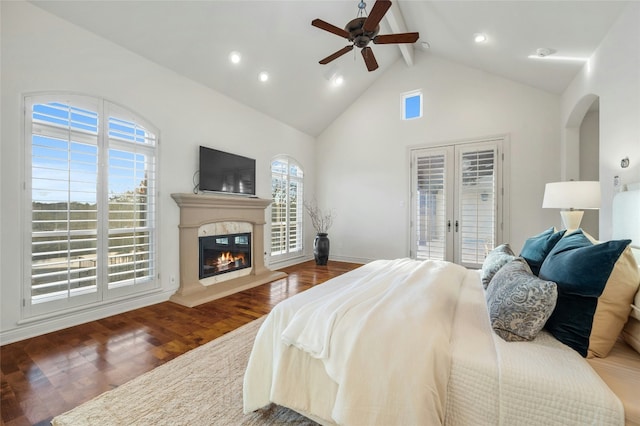 bedroom featuring french doors, a glass covered fireplace, wood finished floors, access to outside, and beamed ceiling