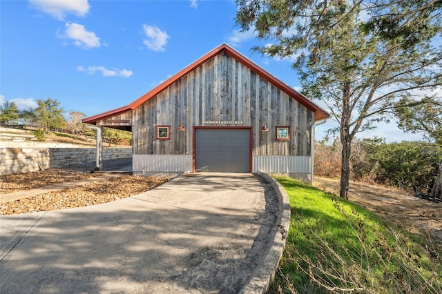 exterior space featuring an outbuilding, concrete driveway, and a detached garage