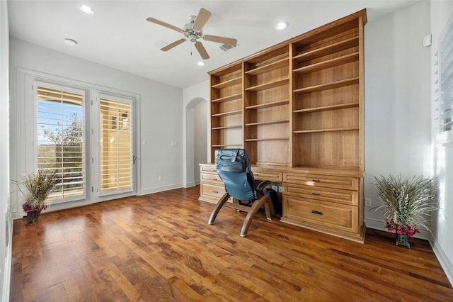 unfurnished office with baseboards, arched walkways, a ceiling fan, dark wood-type flooring, and recessed lighting