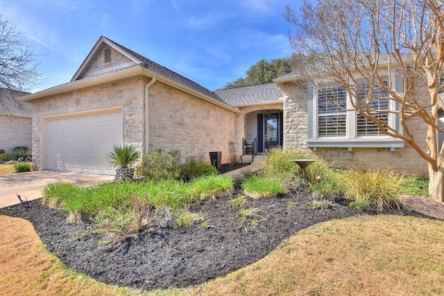 view of front of property featuring a garage, stone siding, a shingled roof, and concrete driveway