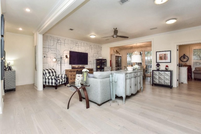 living room with ceiling fan, light wood-type flooring, baseboards, and crown molding