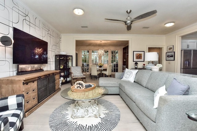 living area featuring ceiling fan, visible vents, and ornamental molding