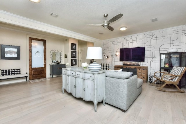 living area featuring ornamental molding, a ceiling fan, and light wood-style floors