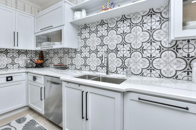 kitchen with white cabinets, dishwasher, a sink, and light stone countertops