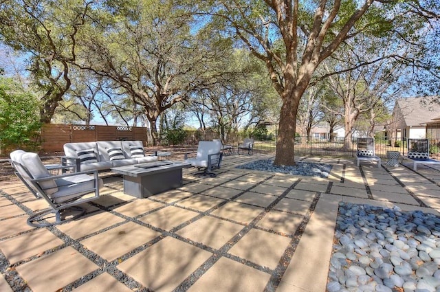 view of patio / terrace with an outdoor living space with a fire pit and fence