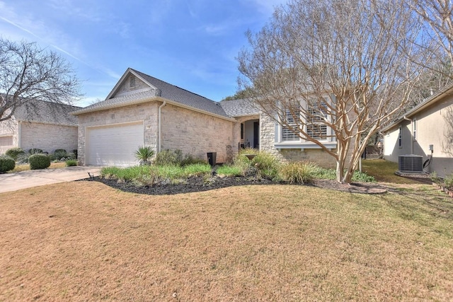 view of front facade featuring central AC unit, a garage, stone siding, driveway, and a front yard