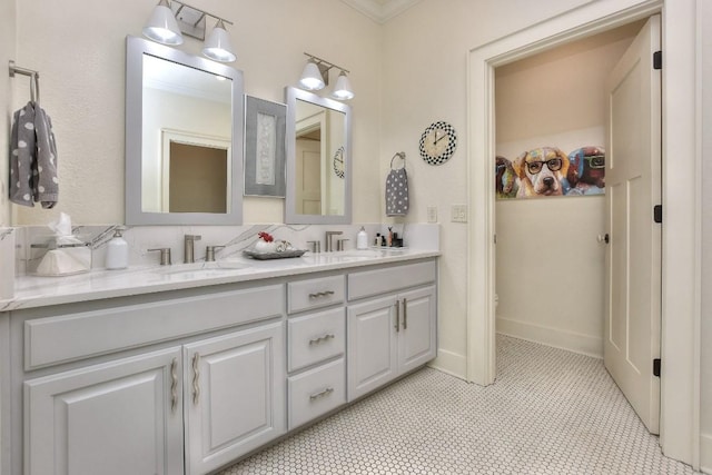 full bathroom with double vanity, baseboards, and a sink