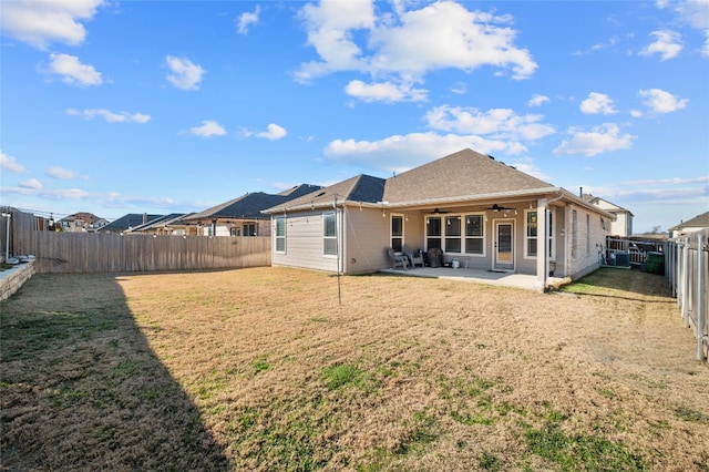 rear view of house featuring a fenced backyard, a lawn, a ceiling fan, and a patio