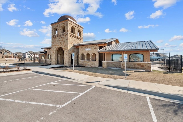 view of property with uncovered parking and fence