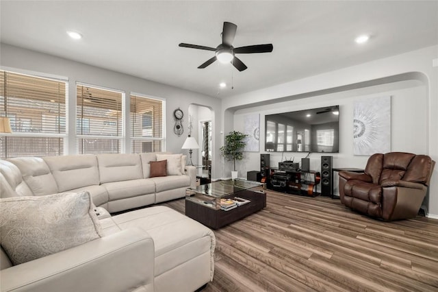 living room featuring arched walkways, ceiling fan, wood finished floors, and recessed lighting