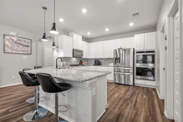3721 Forino Dr, Round Rock, TX 78665 - kitchen with stainless steel appliances, dark wood-style flooring, light stone countertops, a breakfast bar area, and backsplash