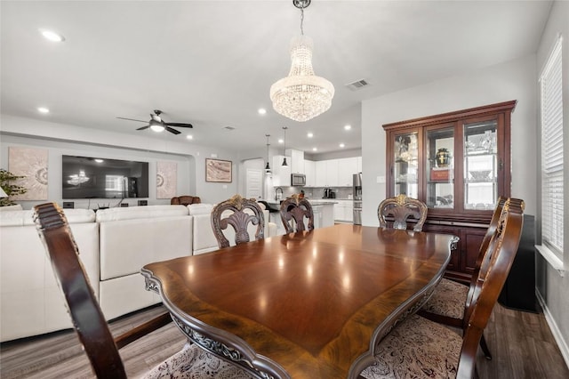 dining room featuring ceiling fan with notable chandelier, wood finished floors, visible vents, and recessed lighting