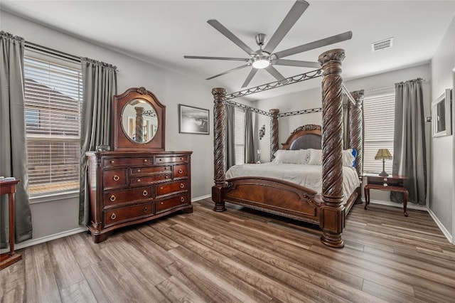 bedroom featuring visible vents, baseboards, and wood finished floors