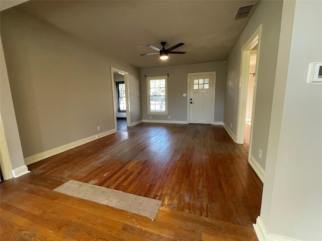 foyer featuring a ceiling fan, dark wood-style flooring, visible vents, and baseboards