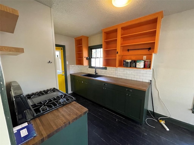 kitchen featuring butcher block countertops, dark wood-style flooring, a sink, decorative backsplash, and open shelves