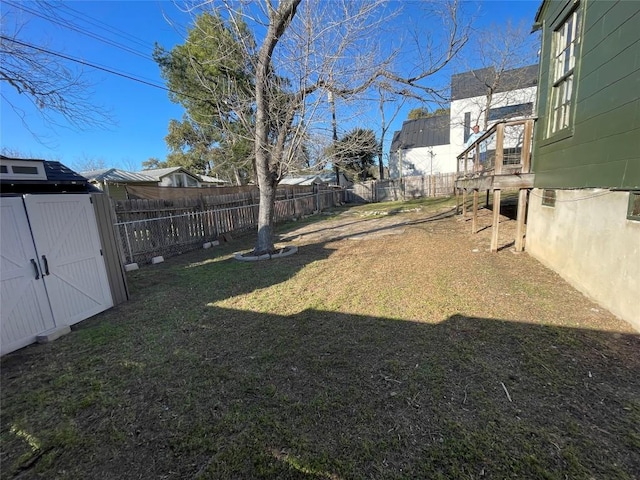 view of yard with a fenced backyard, a storage unit, and an outdoor structure