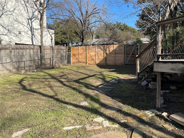 view of yard featuring a fenced backyard and a gate