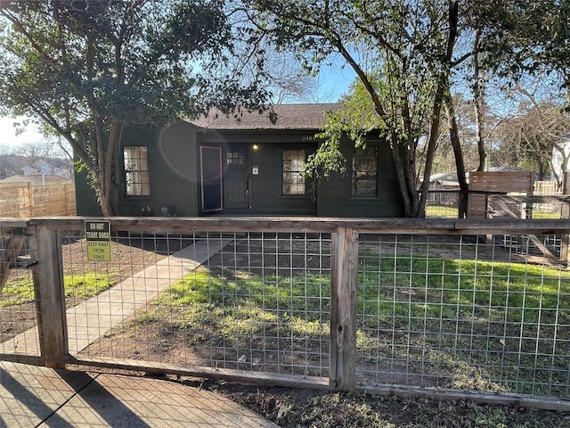 view of front of property featuring a fenced front yard and roof with shingles