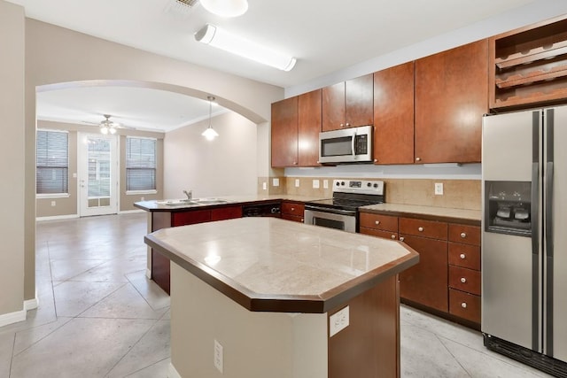 2505 San Gabriel St Unit 212, Austin, TX 78705 - kitchen featuring stainless steel appliances, arched walkways, a peninsula, backsplash, and open floor plan