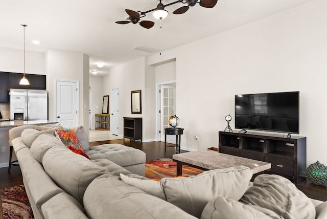 living area with visible vents, baseboards, dark wood-style flooring, and a ceiling fan