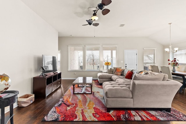 living area with dark wood-style flooring, lofted ceiling, visible vents, baseboards, and ceiling fan with notable chandelier