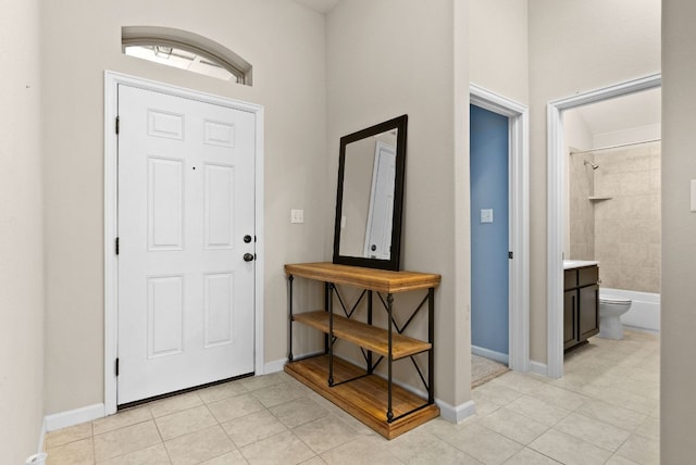 entrance foyer with light tile patterned floors and baseboards