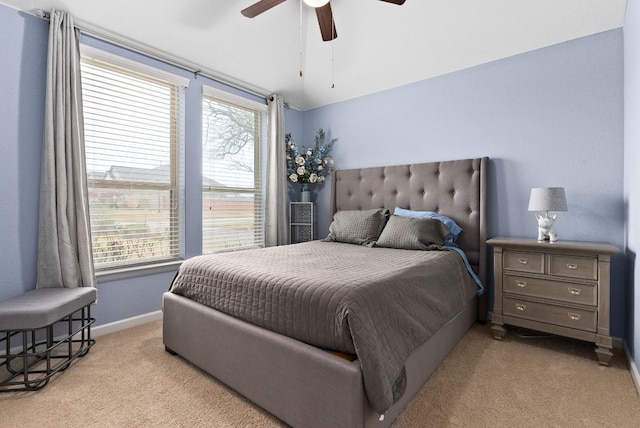 bedroom featuring light carpet, baseboards, a ceiling fan, and lofted ceiling