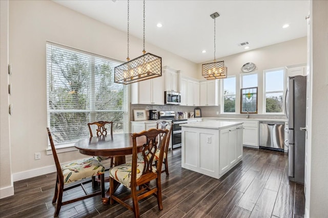kitchen featuring a center island, visible vents, backsplash, light countertops, and appliances with stainless steel finishes
