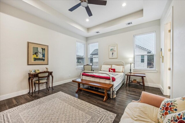 bedroom featuring a tray ceiling, recessed lighting, baseboards, visible vents, and wood finished floors