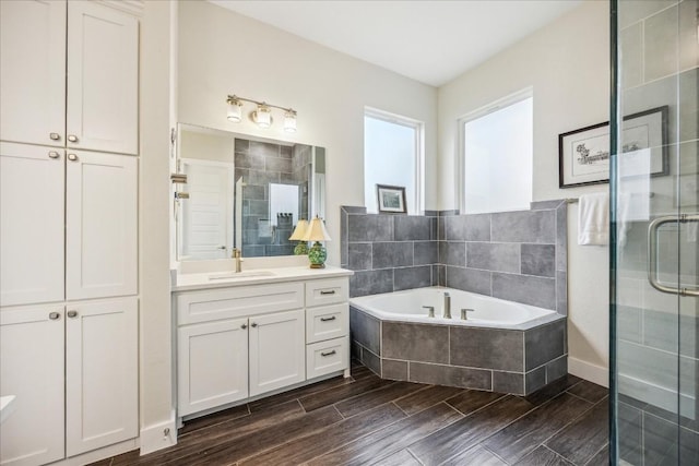 bathroom featuring a shower stall, a bath, vanity, and wood finish floors