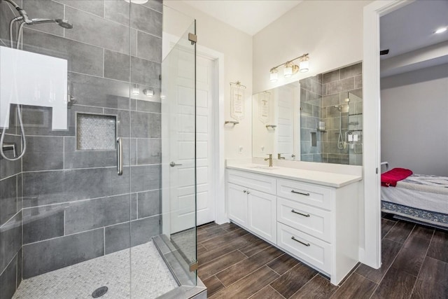 full bath featuring a shower stall, wood tiled floor, connected bathroom, and vanity