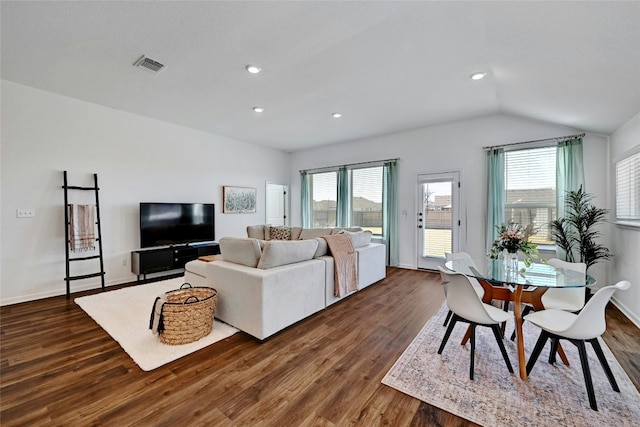 living room with visible vents, baseboards, dark wood-style flooring, and vaulted ceiling