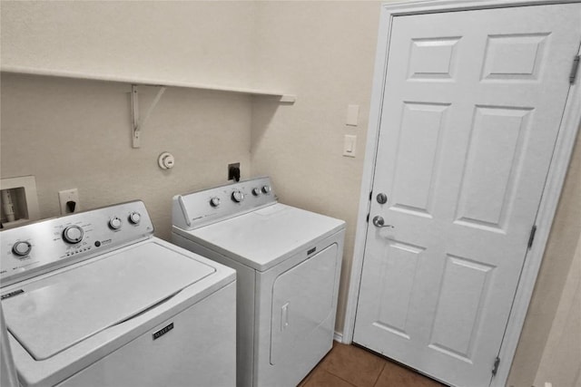 clothes washing area with laundry area, washer and clothes dryer, and dark tile patterned floors