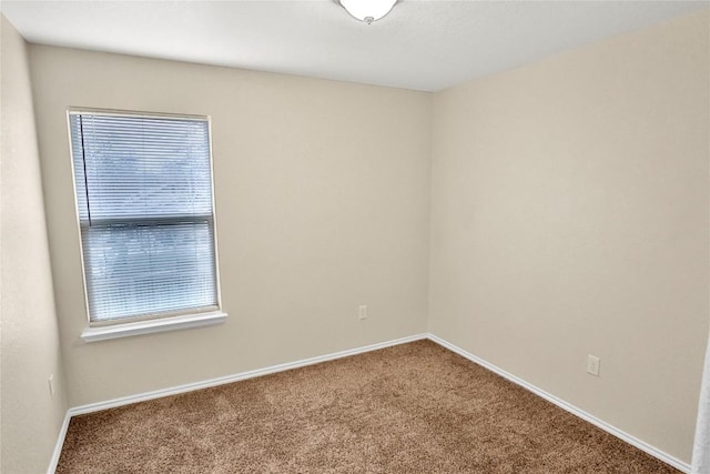 carpeted spare room with baseboards