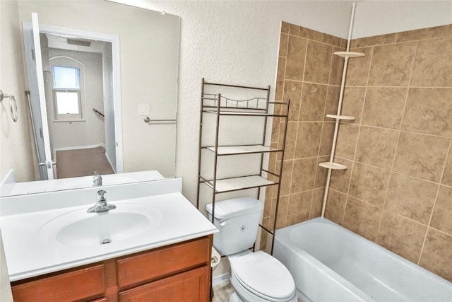 bathroom with a textured wall, vanity, toilet, and shower / bathtub combination