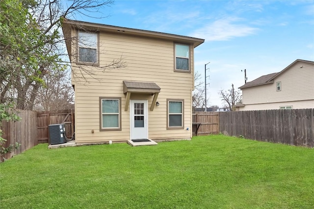 rear view of house with a fenced backyard, a yard, and central air condition unit