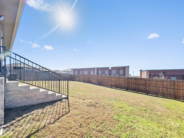 view of yard with stairway and a fenced backyard