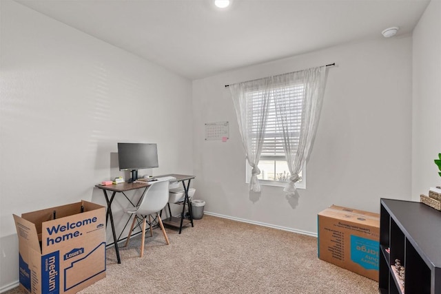 office area featuring light carpet and baseboards