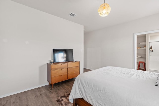 bedroom with dark wood-style flooring, visible vents, and baseboards