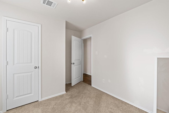 unfurnished bedroom featuring light colored carpet, visible vents, and baseboards