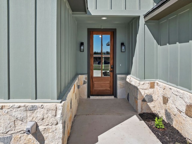 entrance to property with board and batten siding and stone siding