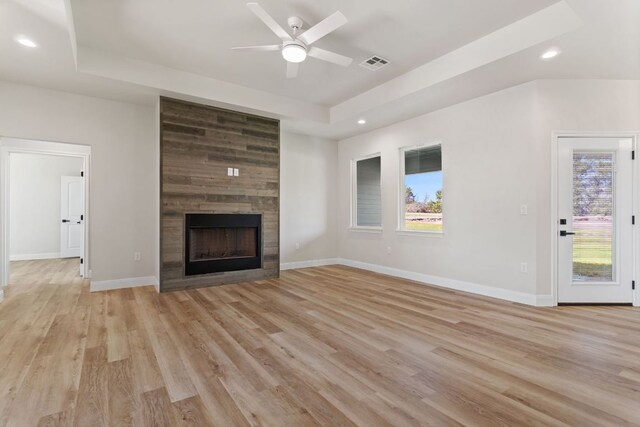 1730 County Road 217, Giddings, TX 78942 - unfurnished living room with a raised ceiling, plenty of natural light, a ceiling fan, recessed lighting, and a large fireplace