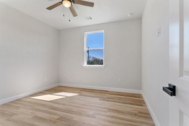 empty room with light wood finished floors, baseboards, and visible vents