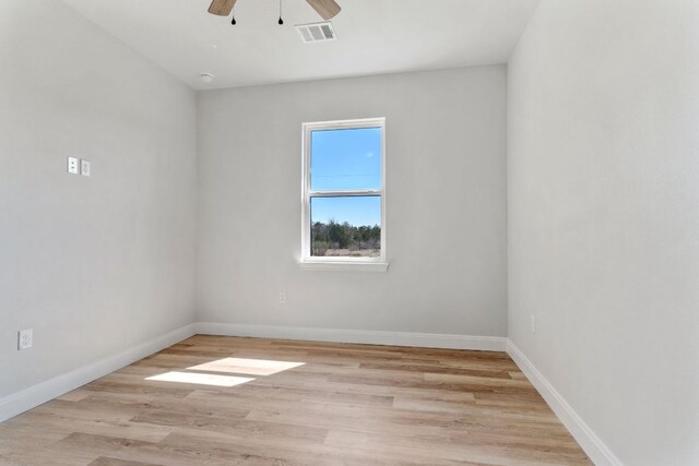 unfurnished room featuring ceiling fan, light wood-type flooring, visible vents, and baseboards