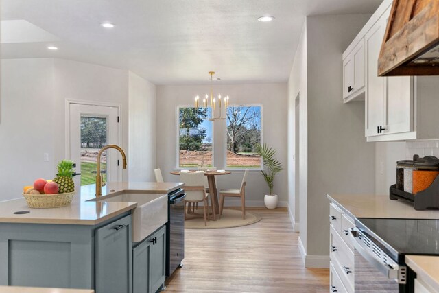 1730 County Road 217, Giddings, TX 78942 - kitchen featuring range hood, light wood-style floors, recessed lighting, light countertops, and white cabinetry
