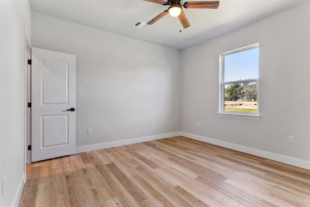 unfurnished room featuring ceiling fan, light wood-type flooring, visible vents, and baseboards