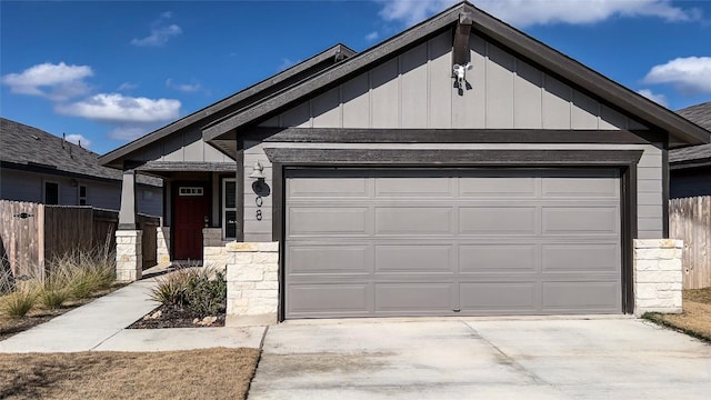 view of front facade featuring an attached garage, stone siding, driveway, and board and batten siding