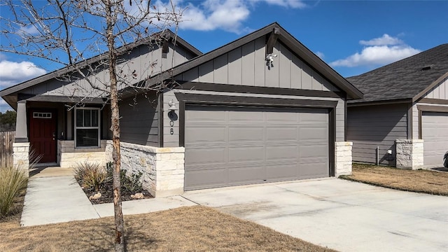 view of front facade featuring concrete driveway, stone siding, board and batten siding, and an attached garage