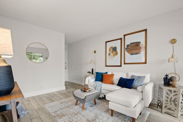 living area with light wood-type flooring and baseboards